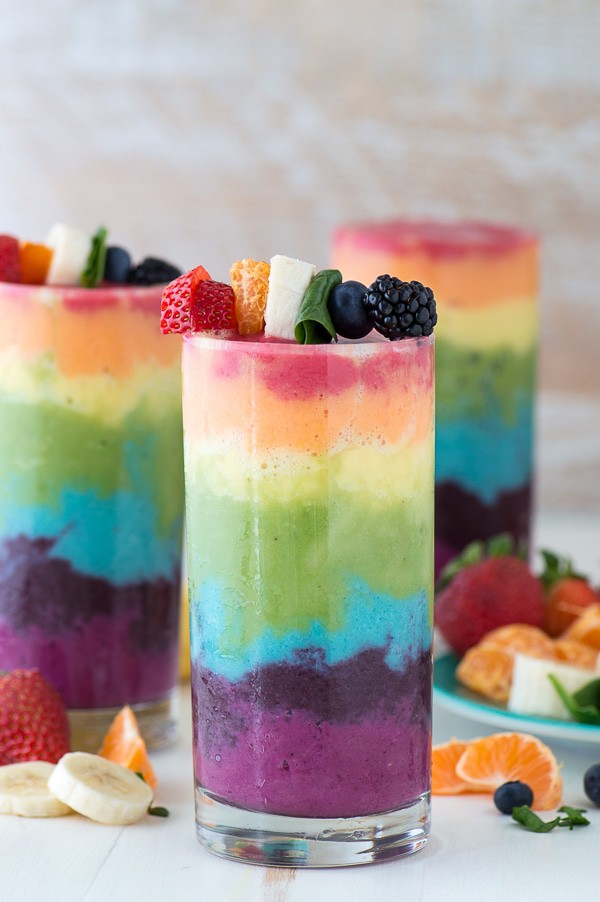 Beautiful 7 layer rainbow smoothie recipe! Full of tons of fruit and topped with a fruit skewer, it’s the ultimate rainbow smoothie! 