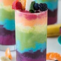 Beautiful 7 layer rainbow smoothie recipe! Full of tons of fruit and topped with a fruit skewer, it’s the ultimate rainbow smoothie!
