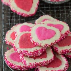 A stack of pink and white Homemade Valentine’s Day Slice N’ Bake Cookies on a cooling rack.