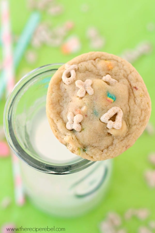 White Chocolate Lucky Charms Cookies in a glass cup of milk.
