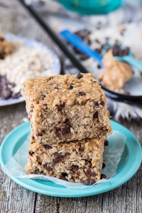 Two Homemade Peanut Butter Chocolate Chip Quinoa Bars on a small blue plate on a wooden table.