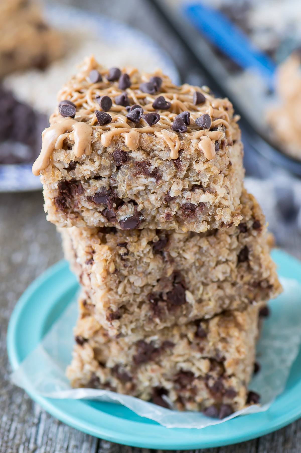 Three stacked Healthy Peanut Butter Chocolate Chip Quinoa Bars on a small blue serving plate.