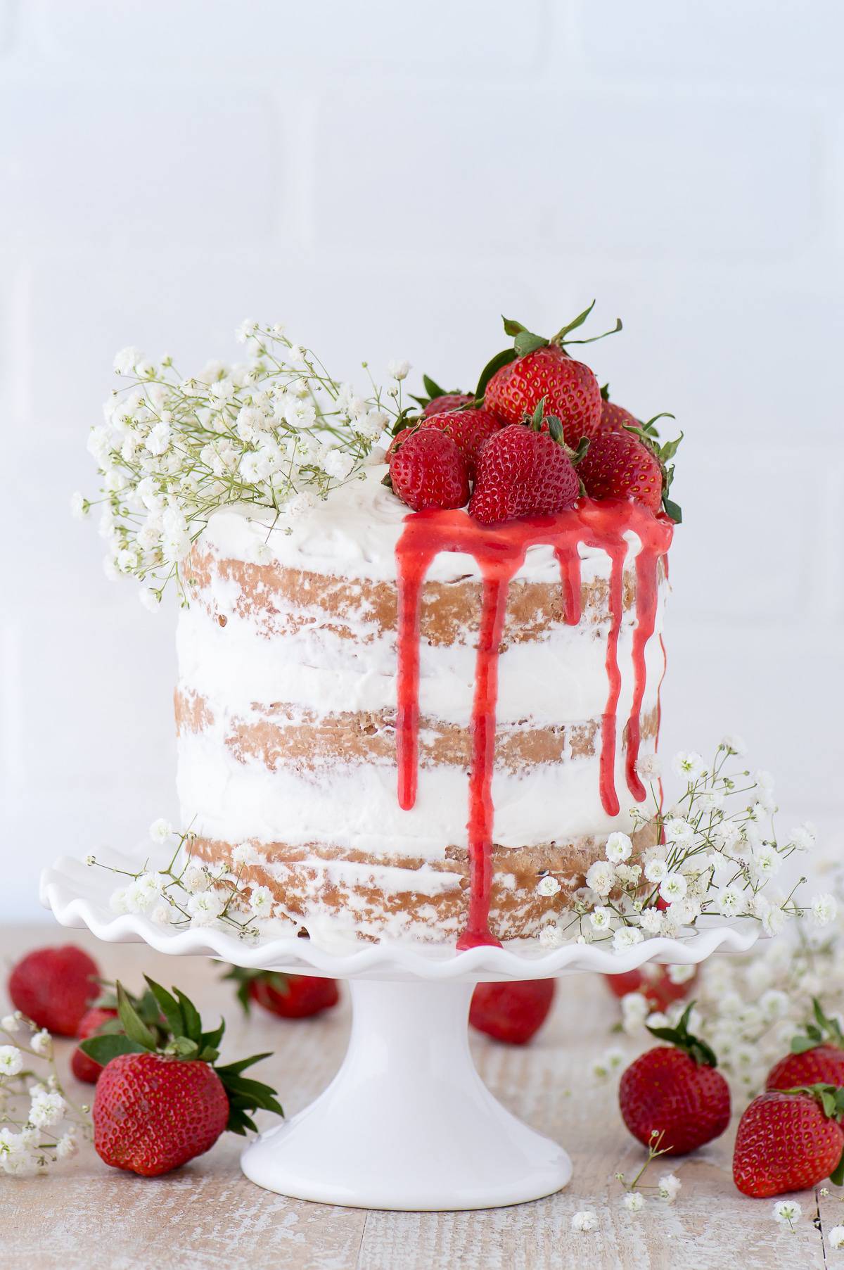 This strawberry naked cake is made with fresh pureed strawberries and is paired with homemade sweet cream whipped cream! Like a strawberries and cream cake!