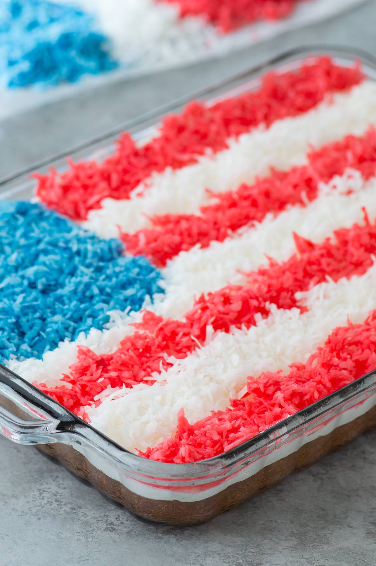 4th of july cake topped with red, white and blue shredded coconut in a flag pattern