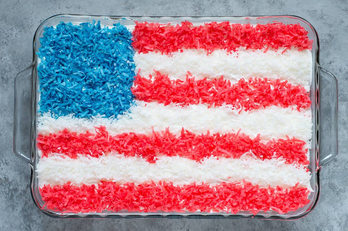 4th of july cake topped with red, white and blue shredded coconut in a flag pattern