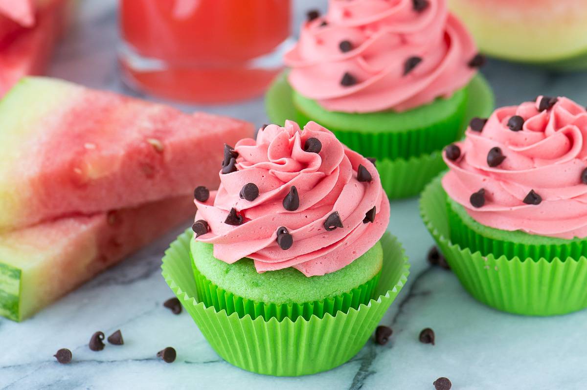 green cupcakes with pink watermelon frosting with mini chocolate chips for watermelon seeds on marble background