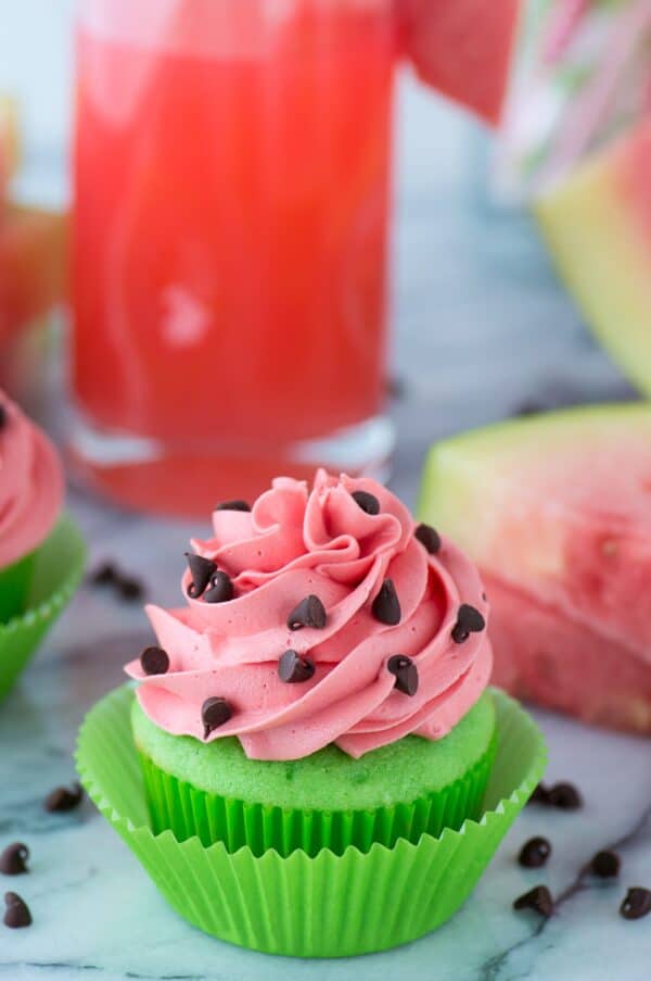 green cupcakes with pink watermelon frosting with mini chocolate chips for watermelon seeds on marble background