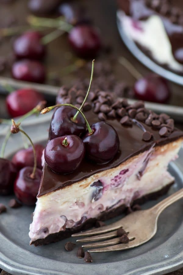 Fresh chocolate cherry cheesecake recipe with a chocolate crust, fresh cherries baked into the cheesecake, dripping with ganache. 