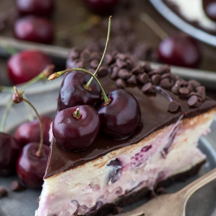 Fresh chocolate cherry cheesecake recipe with a chocolate crust, fresh cherries baked into the cheesecake, dripping with ganache.