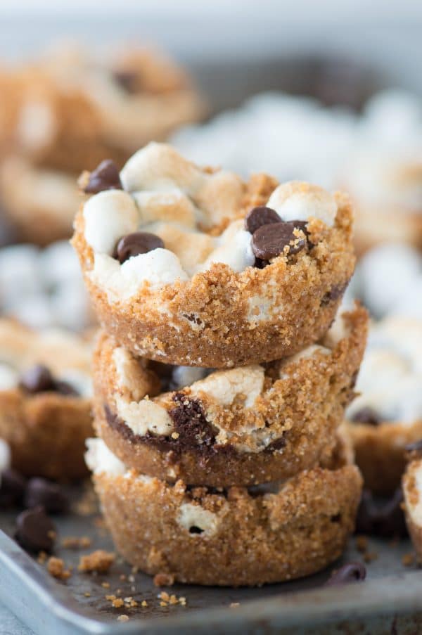 Three stacked easy S’mores Cups surrounded by other homemade s'mores cups on a baking sheet.