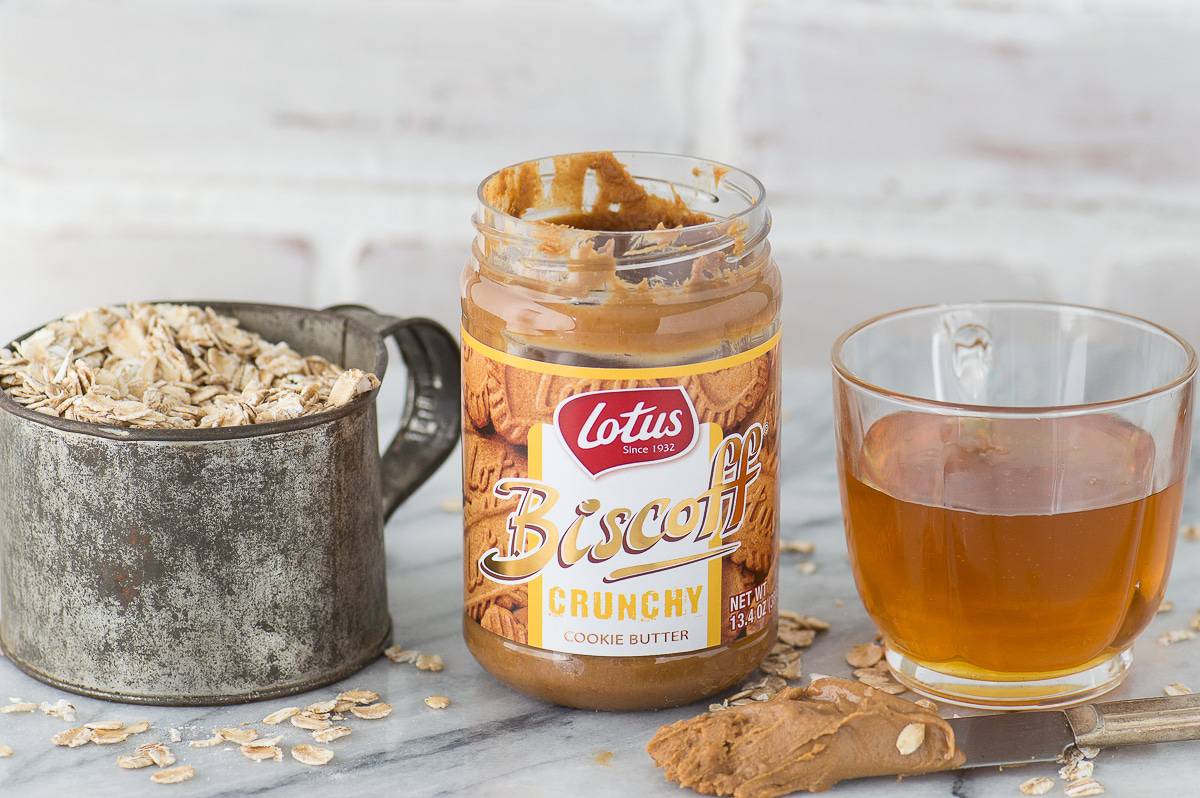 oats in a metal cup, biscoff butter jar and glass jar of honey