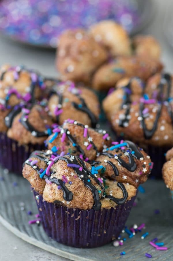 Galaxy Monkey Bread Muffins! Monkey bread turned into muffins with galaxy sprinkles and black cream cheese glaze! These are out of this world! 