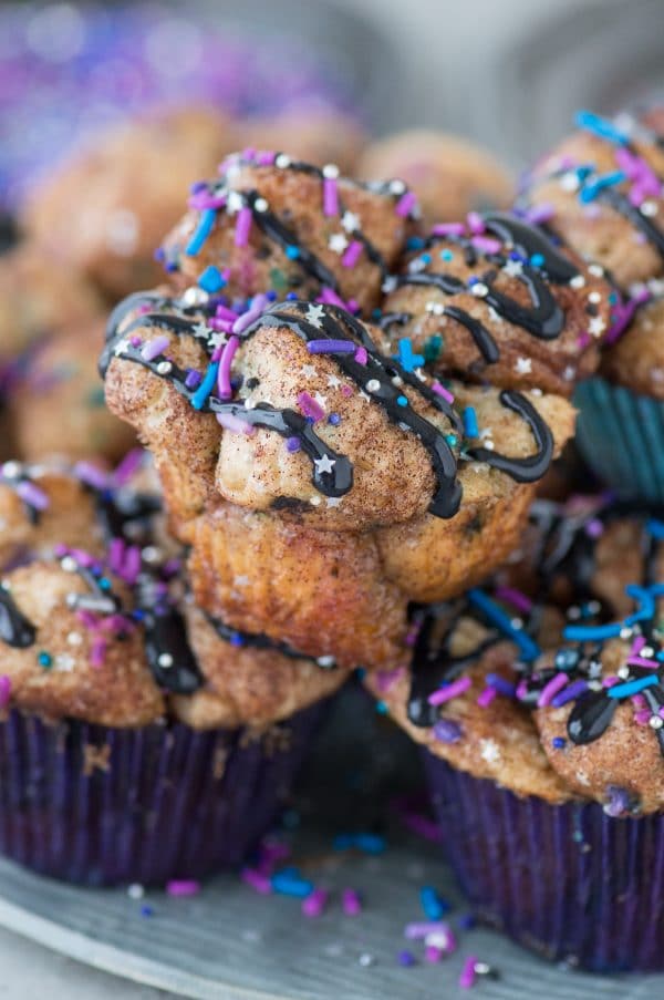 Galaxy Monkey Bread Muffins! Monkey bread turned into muffins with galaxy sprinkles and black cream cheese glaze! These are out of this world! 