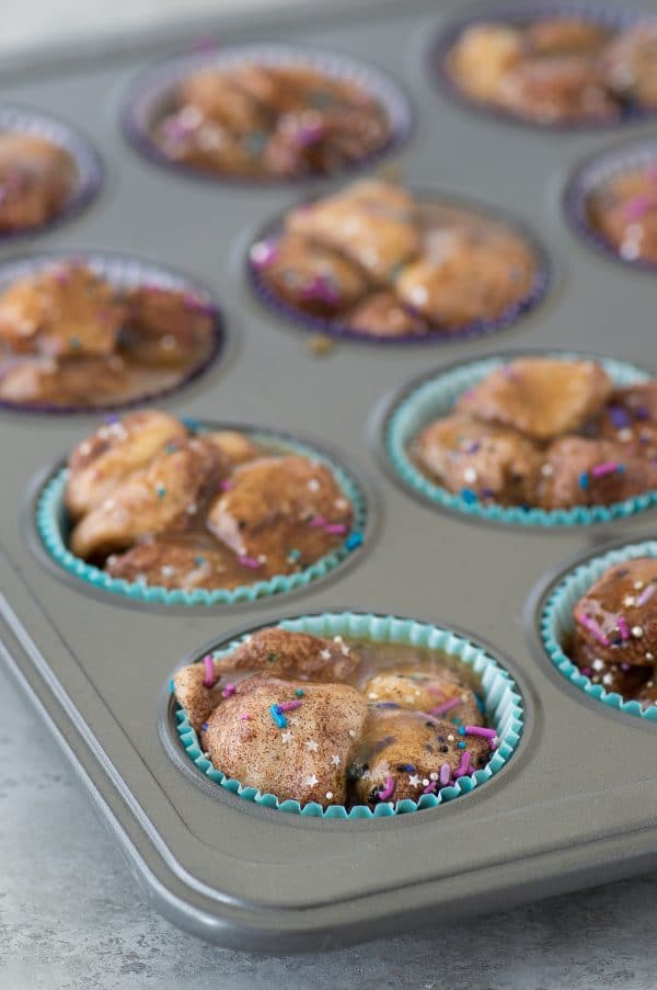 Galaxy Monkey Bread Muffins! Monkey bread turned into muffins with galaxy sprinkles and black cream cheese glaze! These are out of this world! 