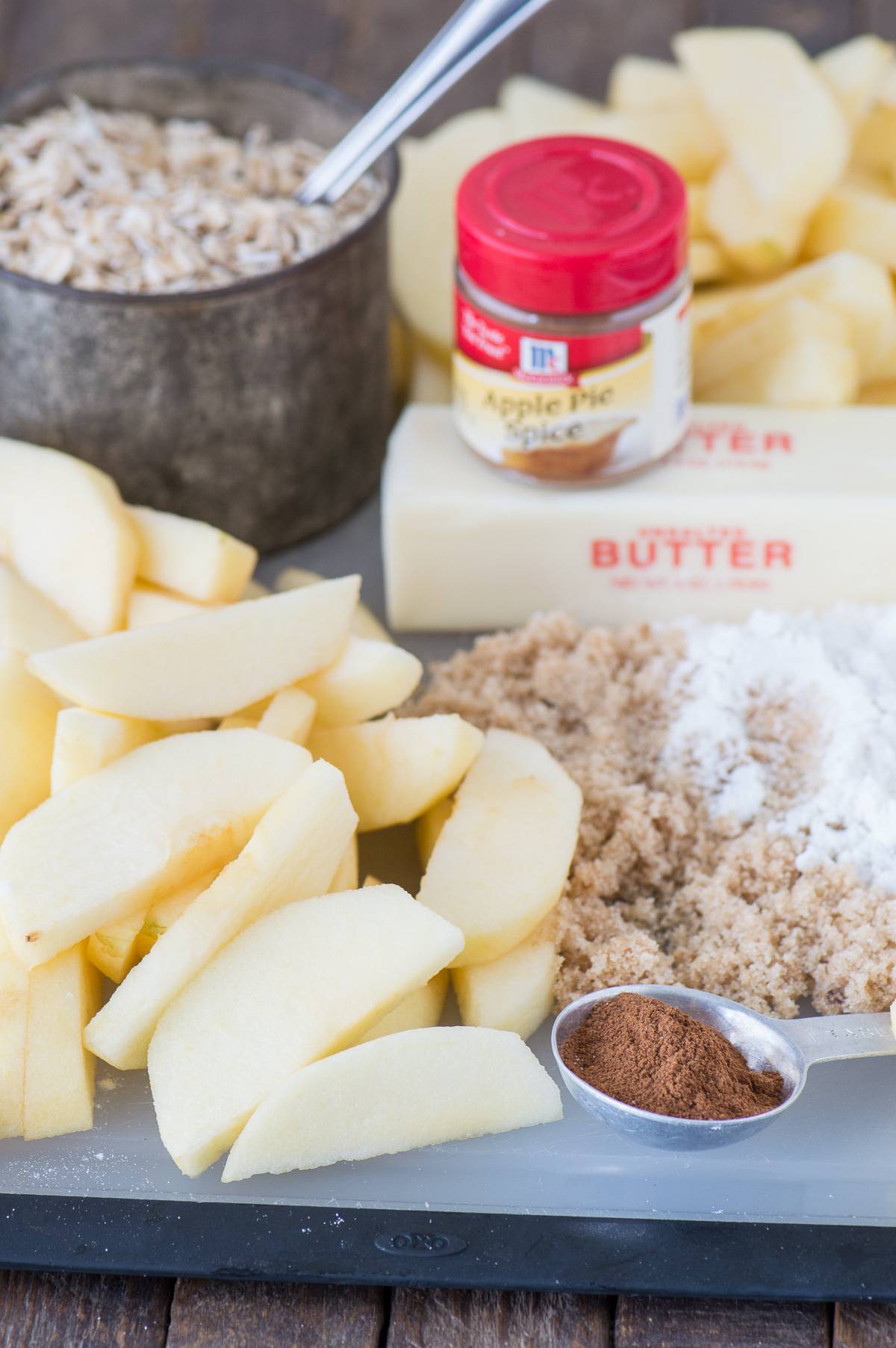 ingredients to make crock pot apple crisp including apples, butter, brown sugar, cinnamon, and oats