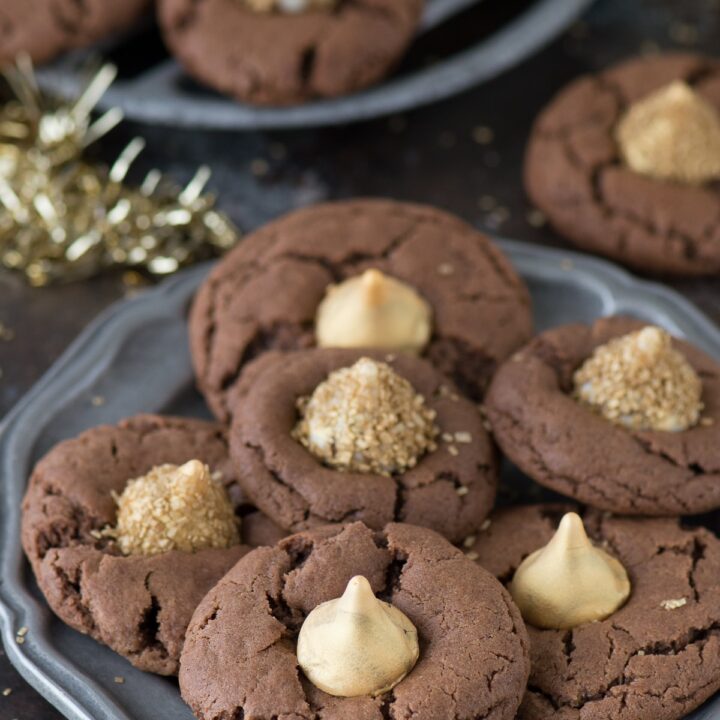 These Midnight Kiss Cookies are the best New Year’s Eve cookie! There are a spin on everyone’s favorite peanut butter blossoms, with a chocolate cookie base and gold hershey’s kisses!