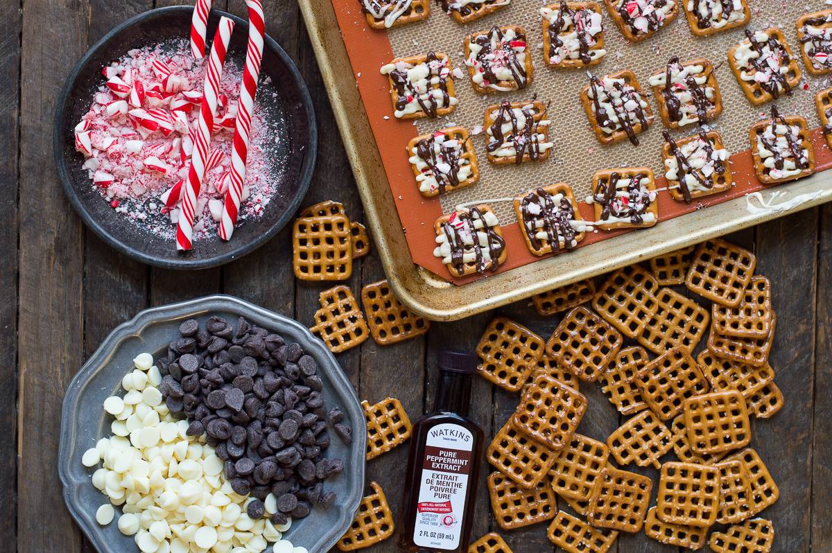 ingredients to make peppermint bark pretzels on wood background