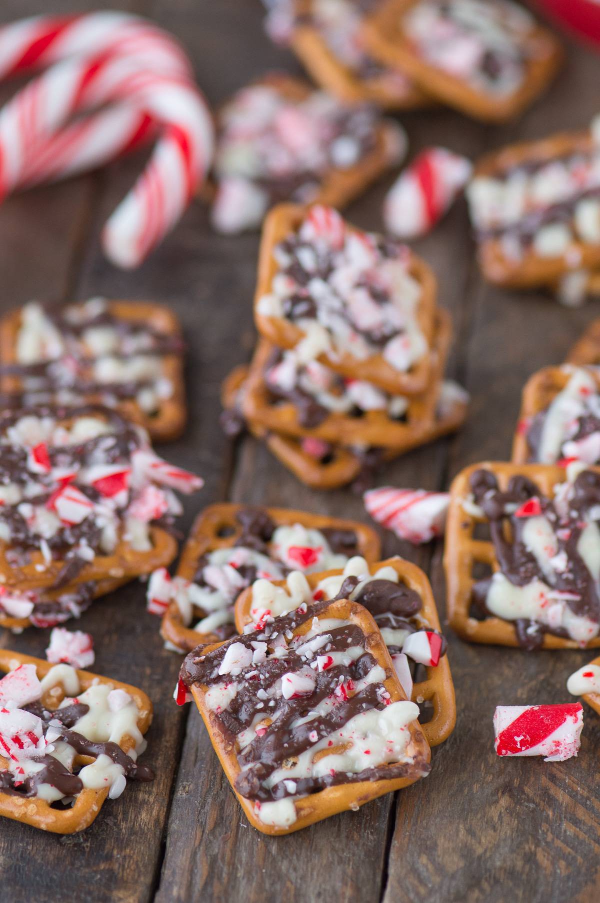 peppermint bark pretzel on wood background with candy cane pieces
