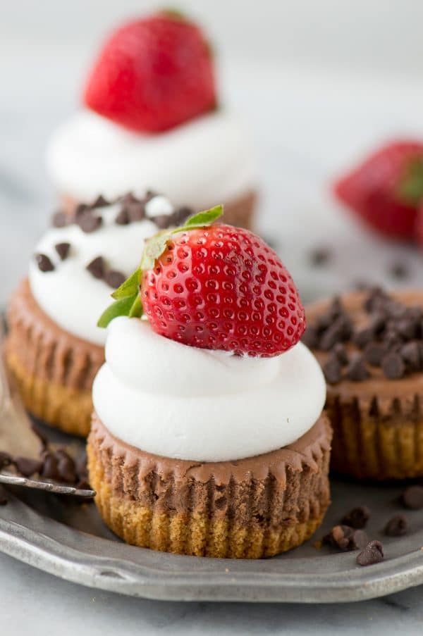 mini chocolate cheesecake with whipped cream and strawberry on metal plate