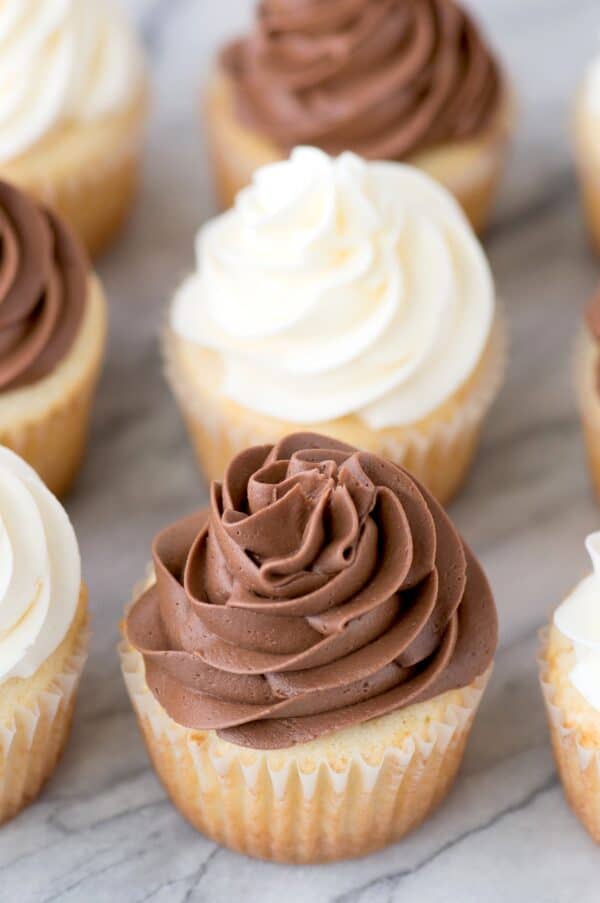 vanilla cupcake with chocolate frosting on marble background