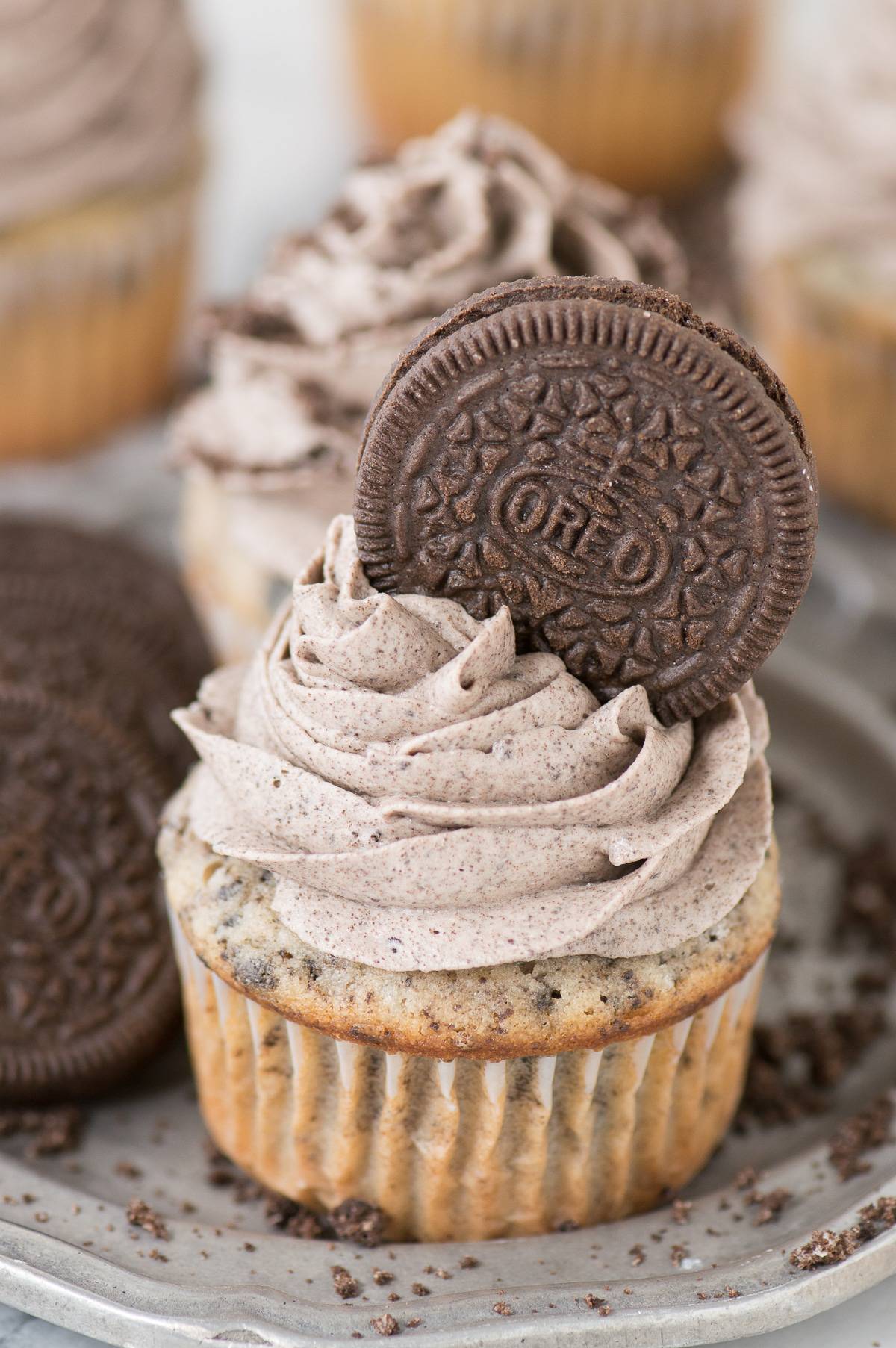 oreo cupcake with oreo frosting and oreo on top of frosting on metal plate