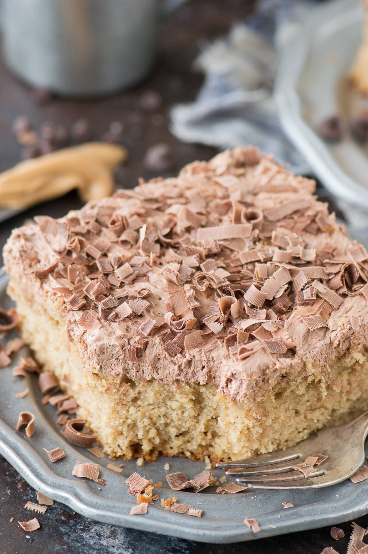 slice of peanut butter cake with chocolate frosting on metal plate