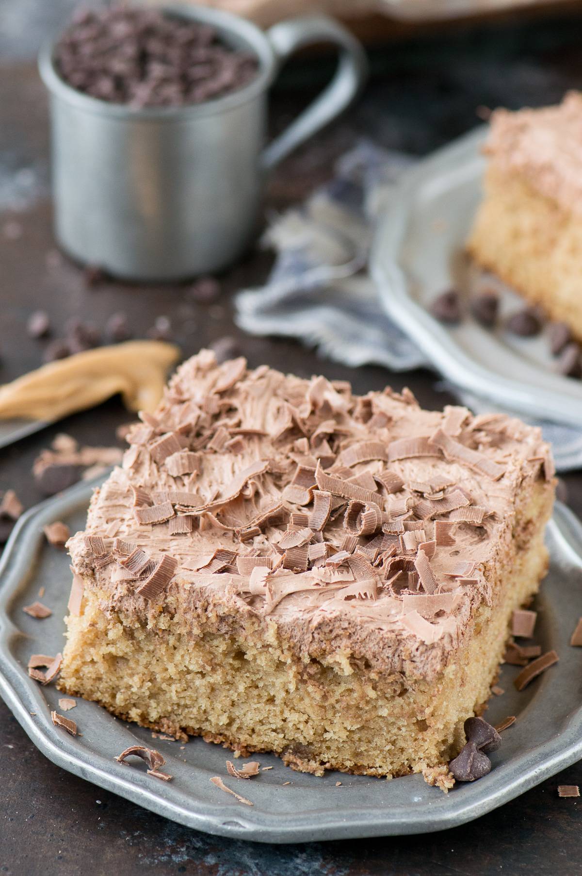 slice of peanut butter cake with chocolate frosting on metal plate