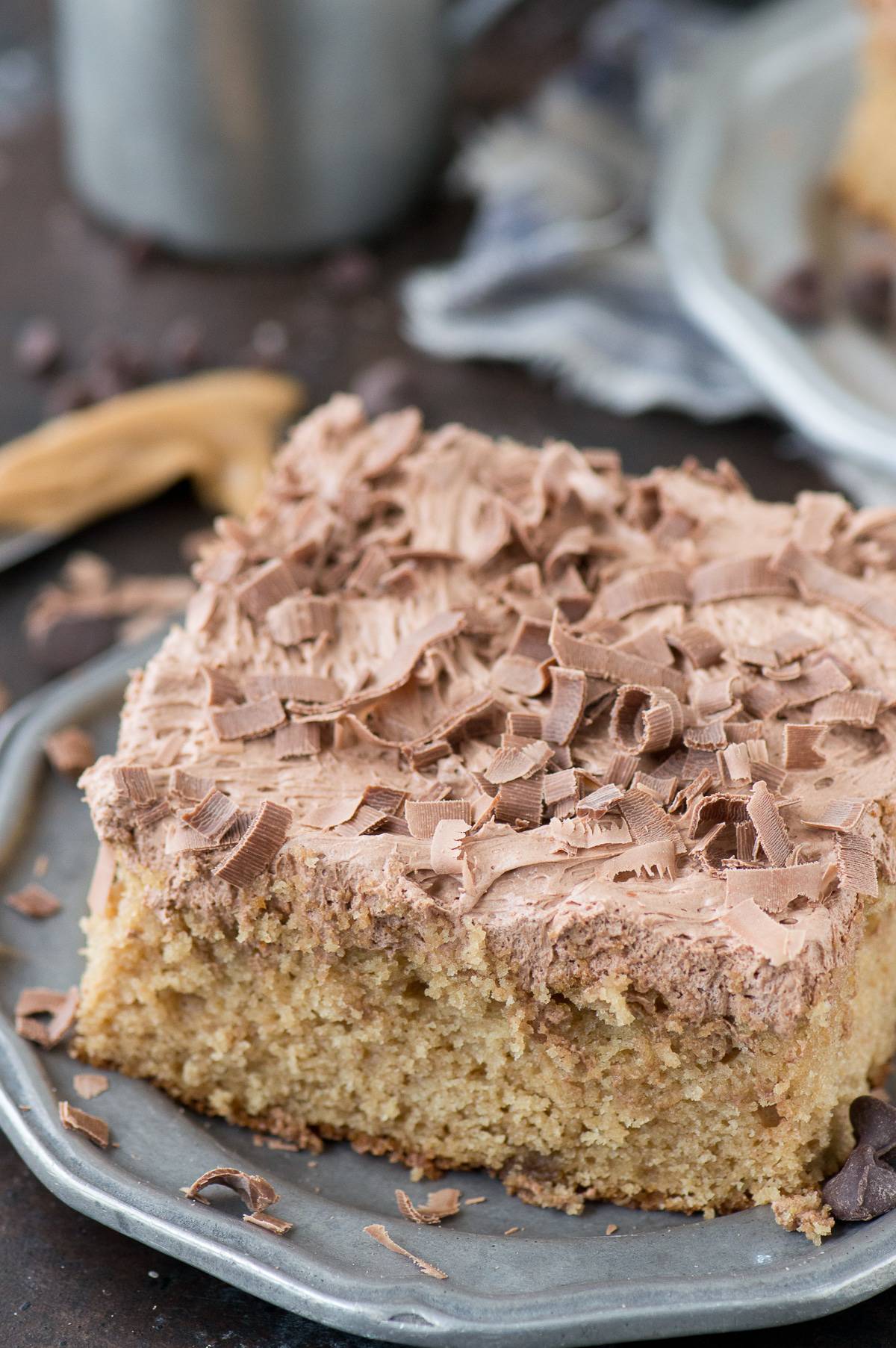 slice of peanut butter cake with chocolate frosting on metal plate