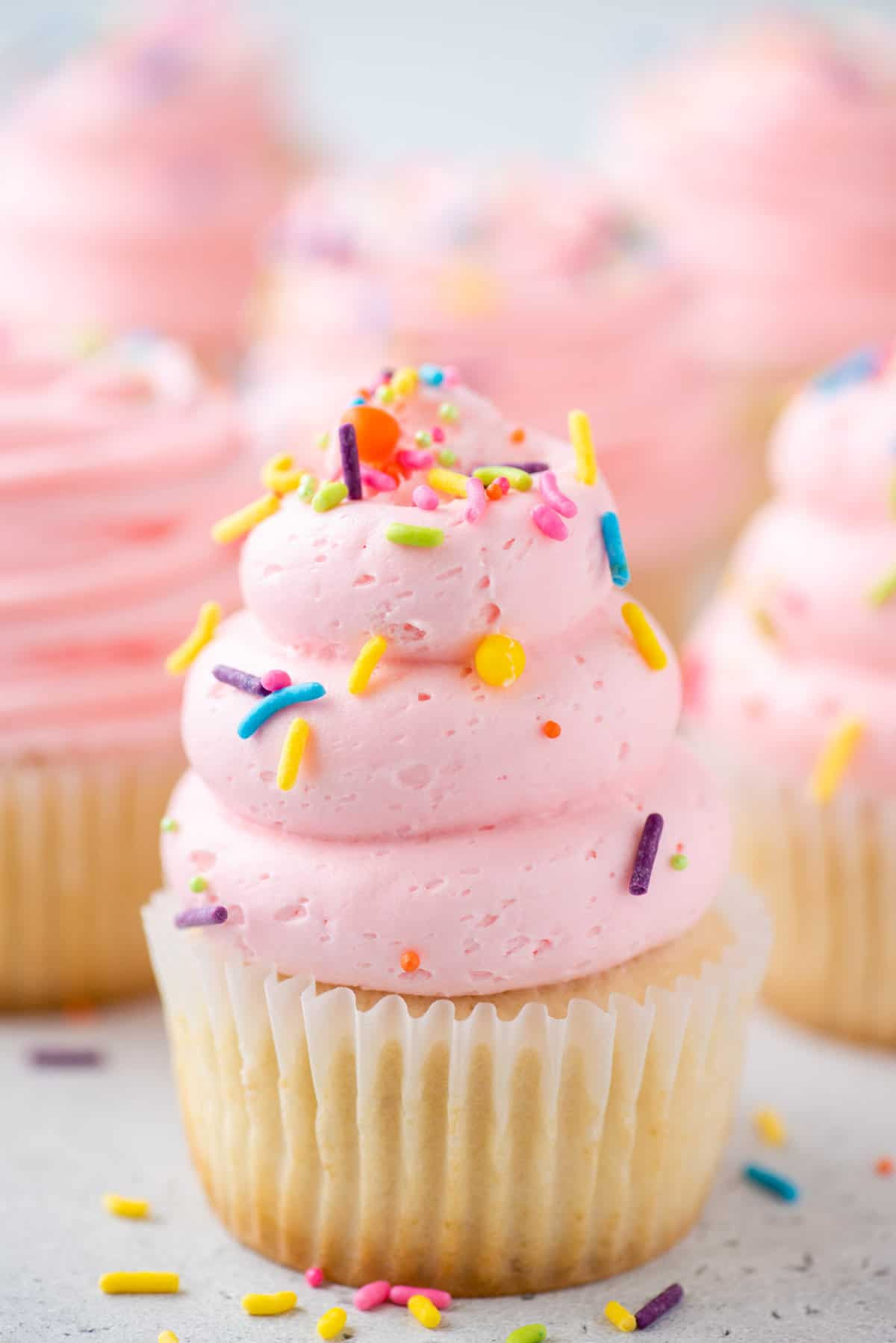 vanilla cupcakes with pink frosting and sprinkles 