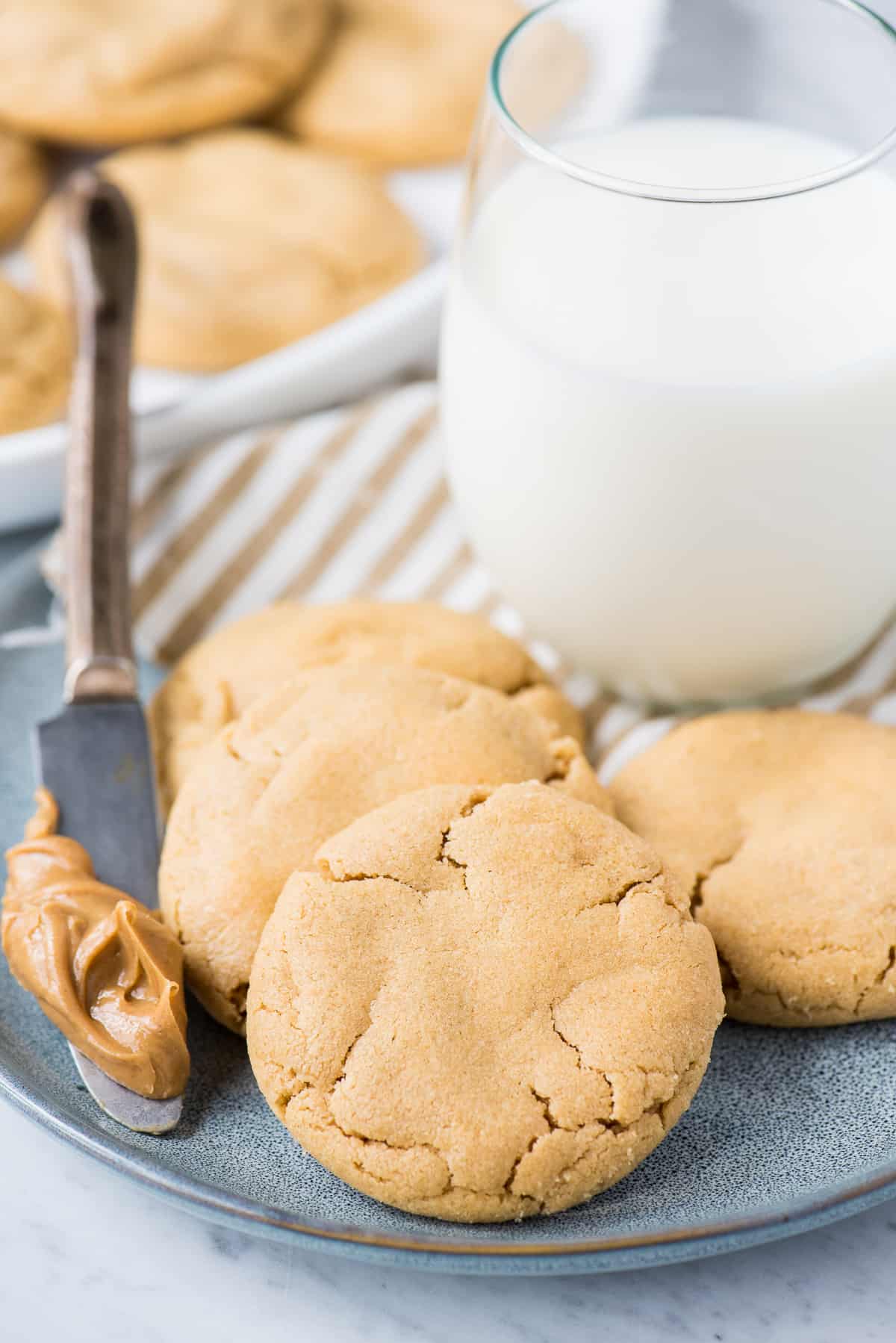 peanut butter cookies on light blue plate with glass of milk