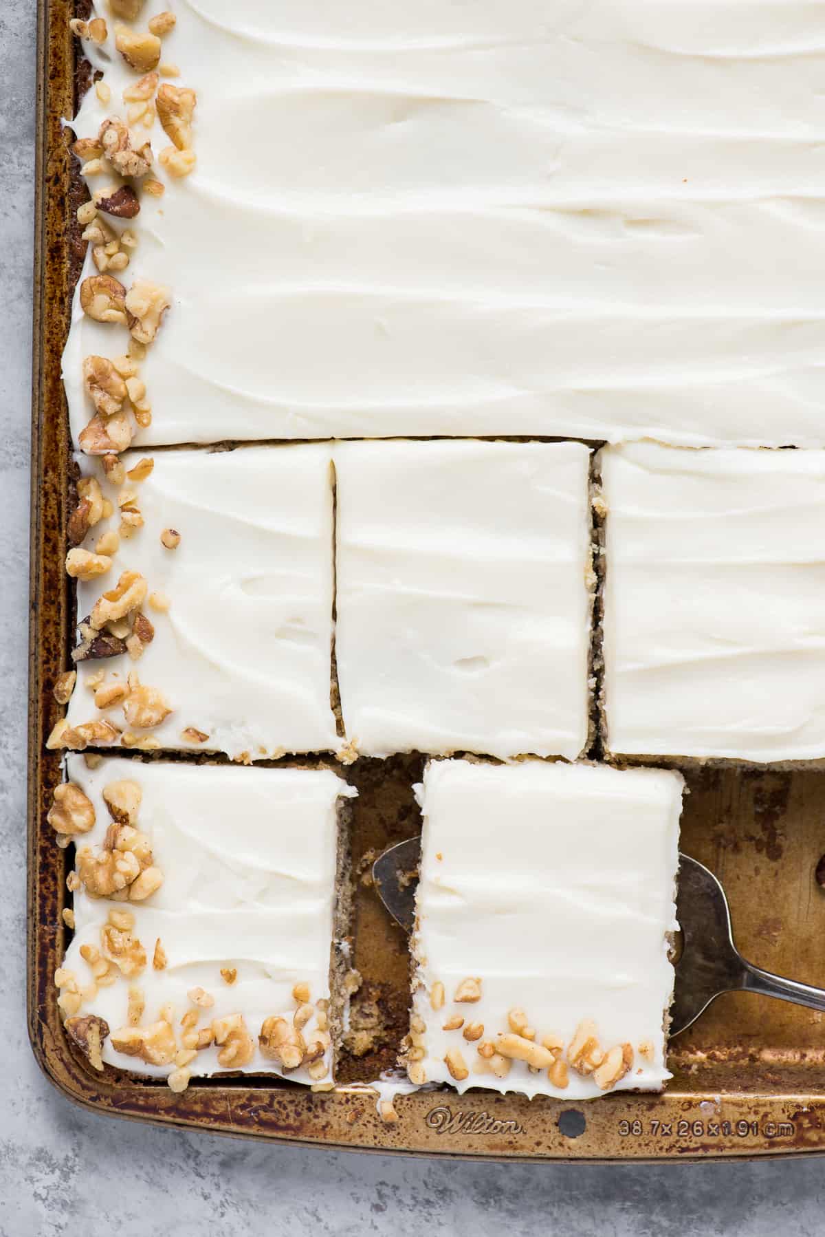 banana bars with cream cheese frosting and walnuts in sheet pan