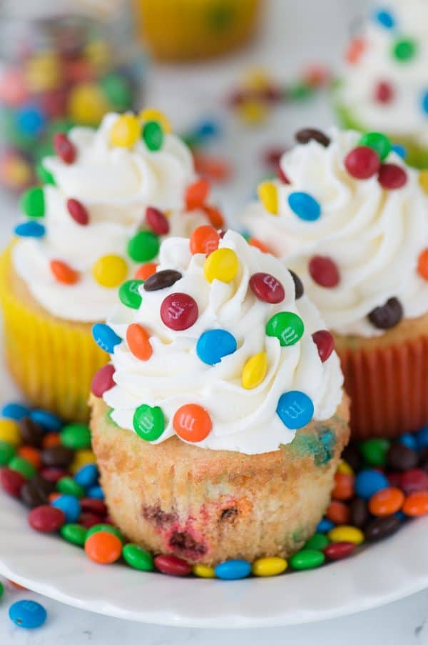 Loaded M&M cupcakes! Moist vanilla cupcakes with mini M&Ms in the batter, topped with vanilla buttercream and more mini M&Ms!