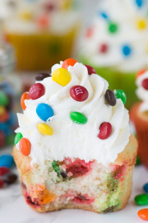 Loaded M&M cupcakes! Moist vanilla cupcakes with mini M&Ms in the batter, topped with vanilla buttercream and more mini M&Ms!