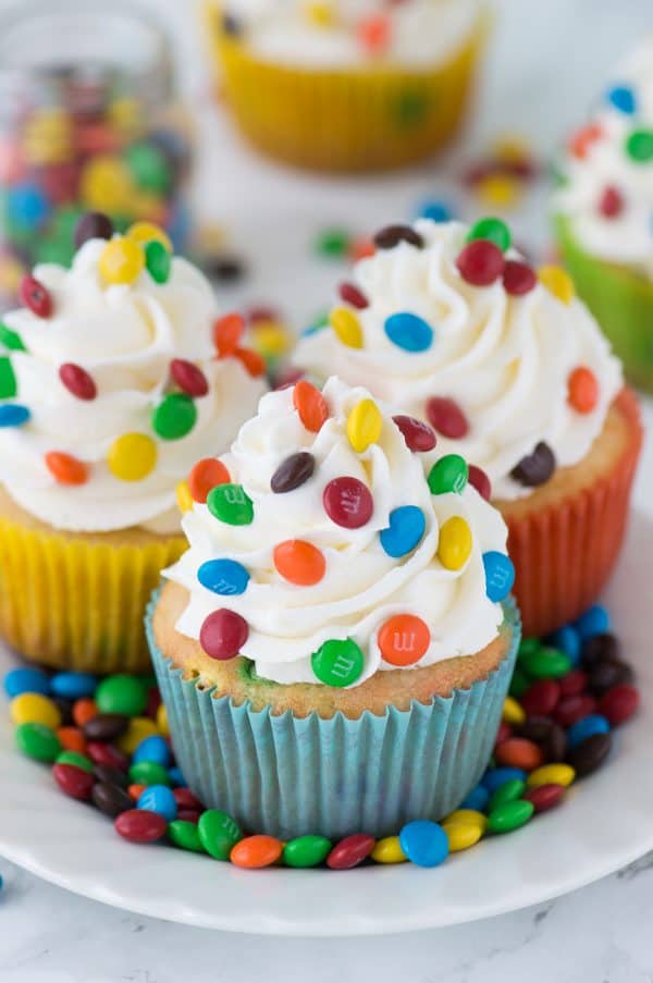 Loaded M&M cupcakes! Moist vanilla cupcakes with mini M&Ms in the batter, topped with vanilla buttercream and more mini M&Ms!