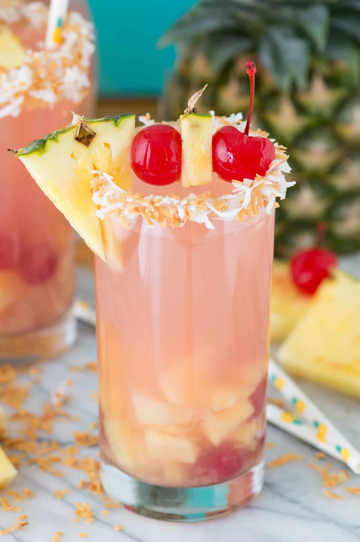 pina colada sangria in a glass cup with pineapple and cherry for garish