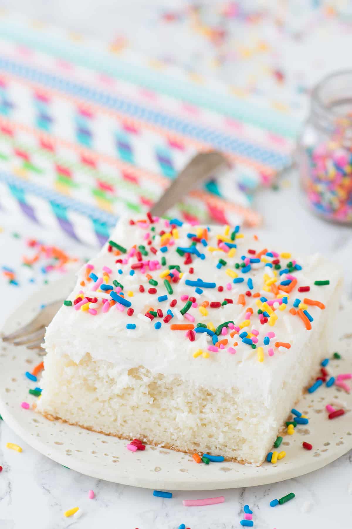 white cake with funfetti sprinkles on white plate