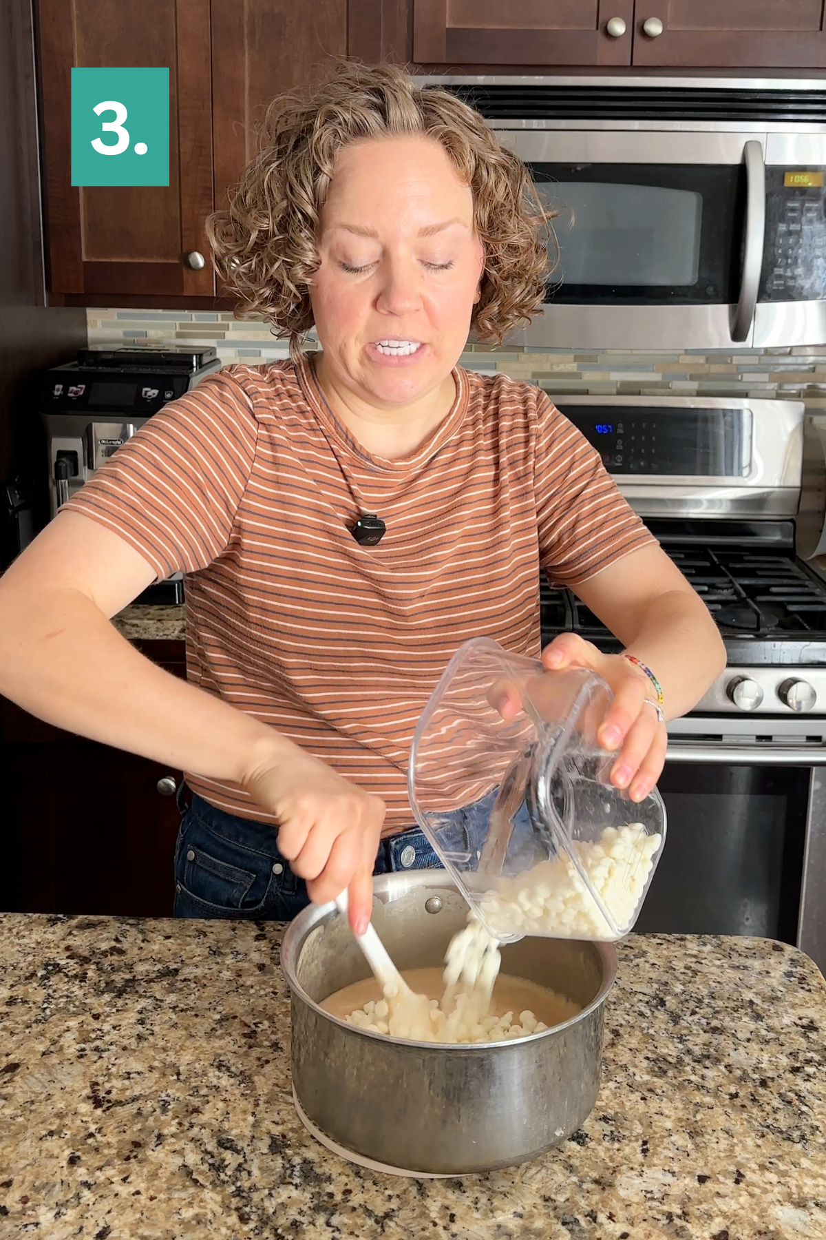 A woman in a striped shirt pours white beans from a blender into a pot on a kitchen counter, perhaps preparing the base for a savory dish or something unexpected like caramel apple fudge. A green box with the number 3 sits in the corner.