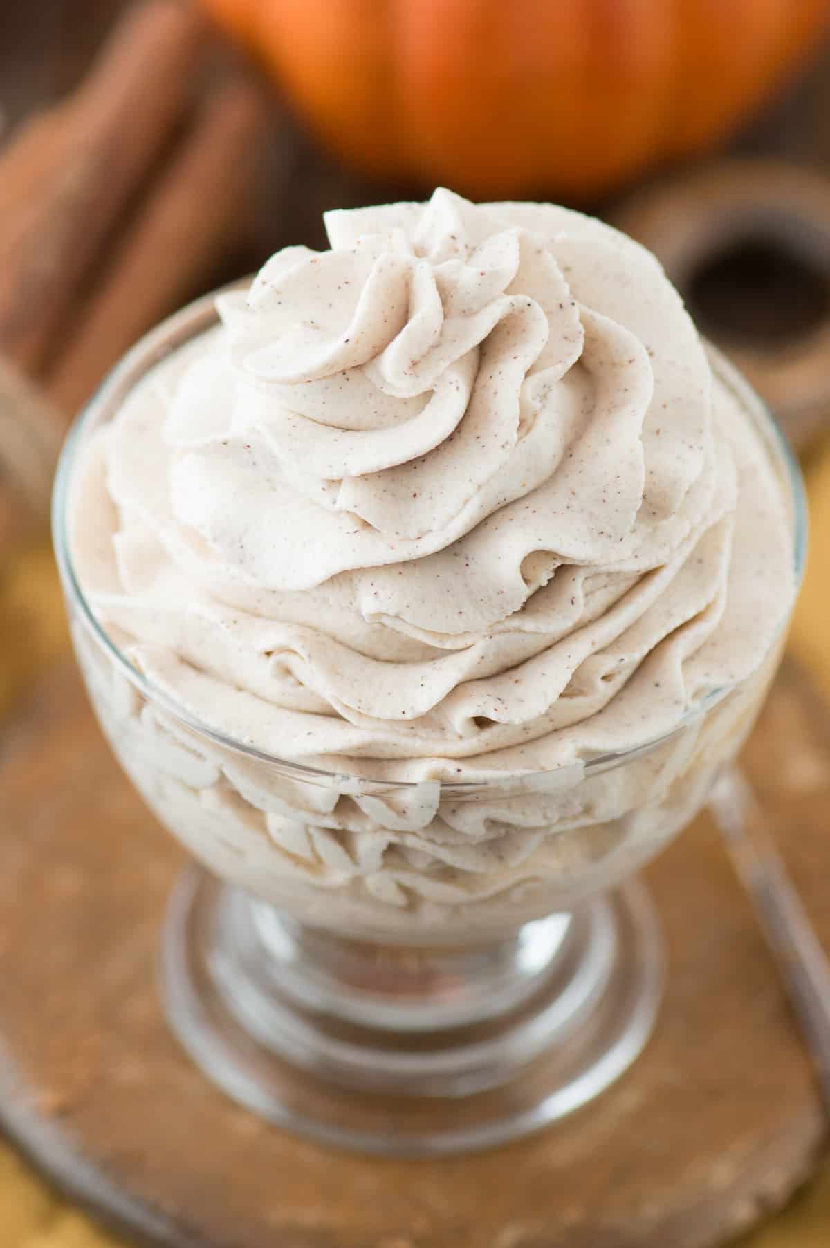 pumpkin whipped cream piped into clear bowl on wooden background