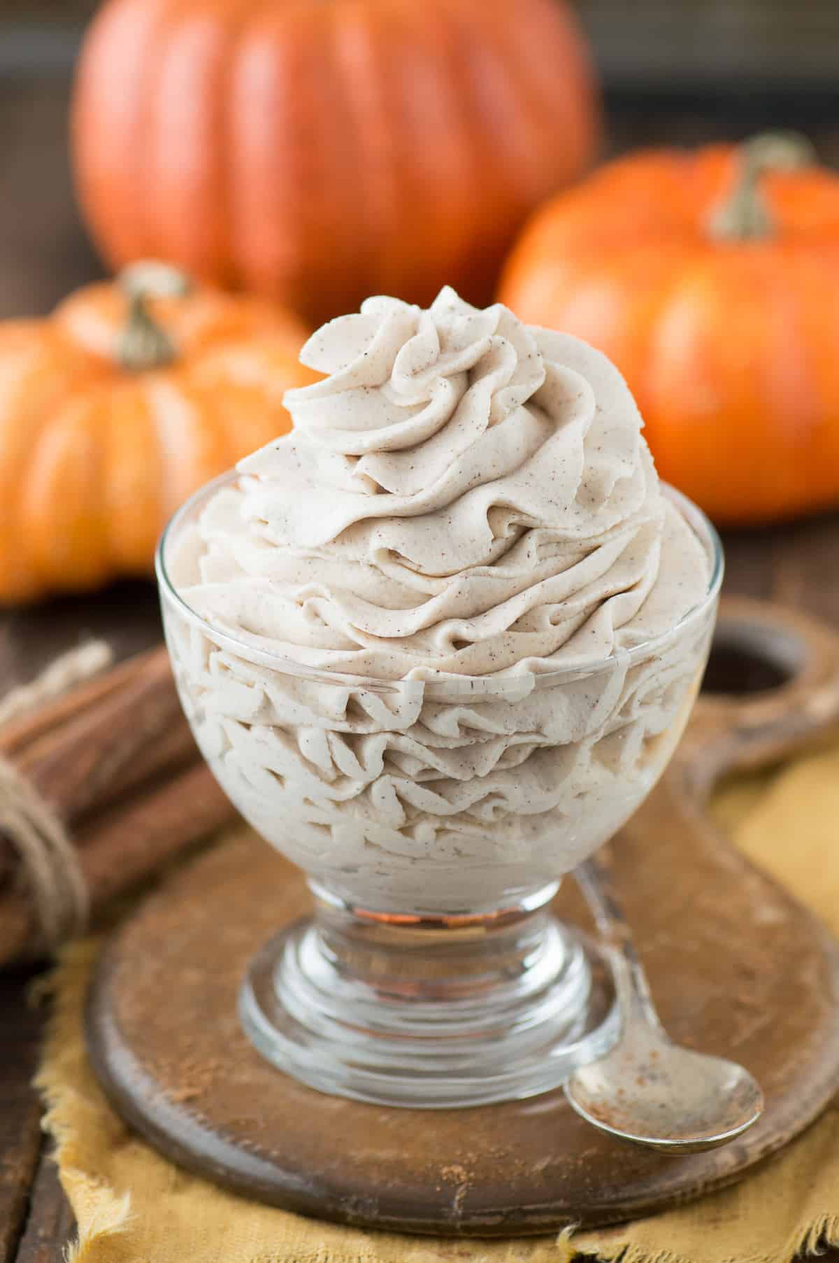 pumpkin whipped cream piped into clear bowl on wooden background