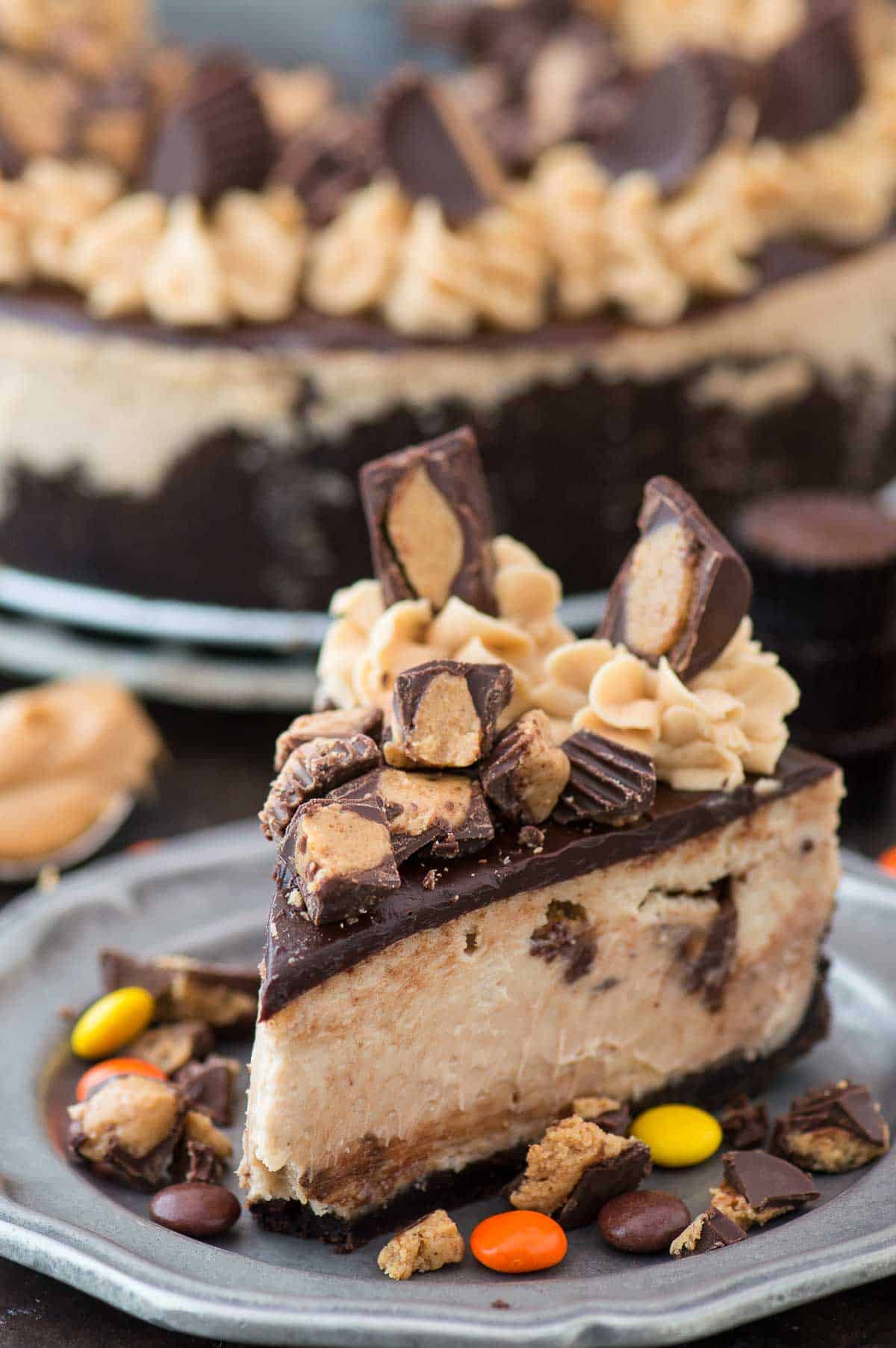 slice of reese's cheesecake with chocolate ganache and more reese's cup on metal plate