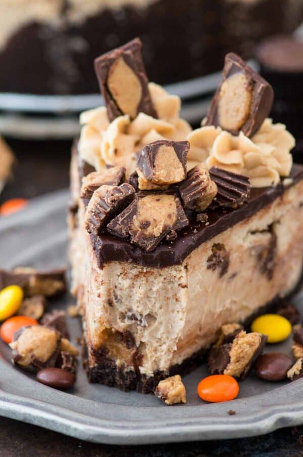 slice of reese's cheesecake with chocolate ganache and more reese's cup on metal plate