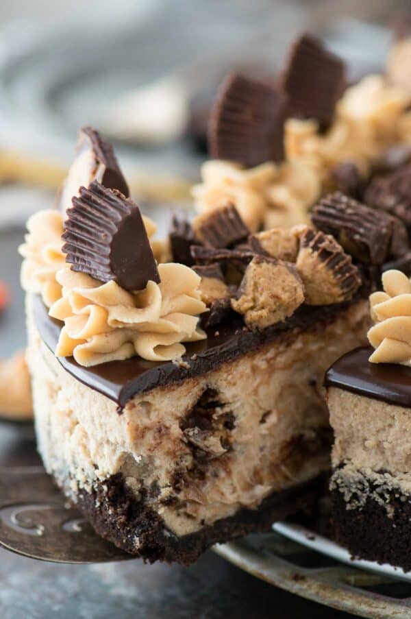 slice of reese's cheesecake with chocolate ganache and more reese's cup on metal plate