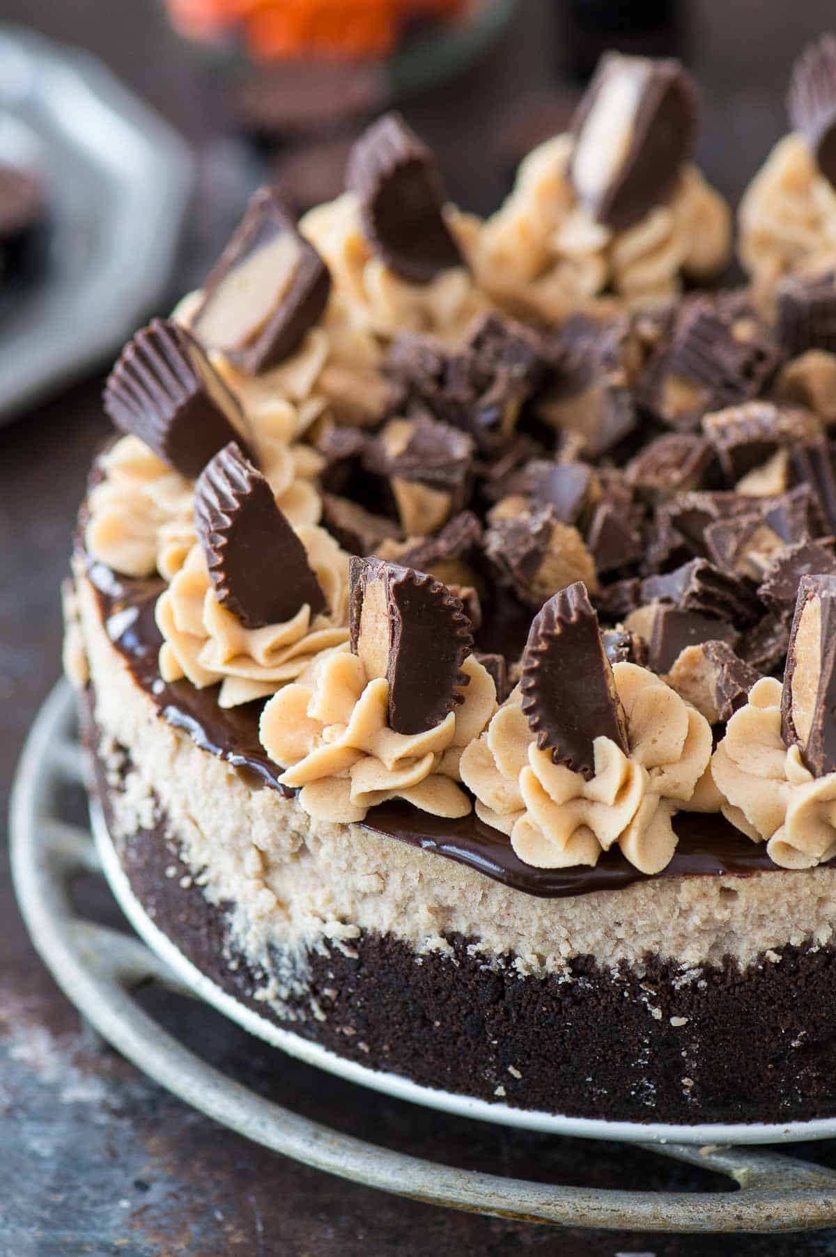 reese's cheesecake with chocolate ganache and more reese's cup on metal plate