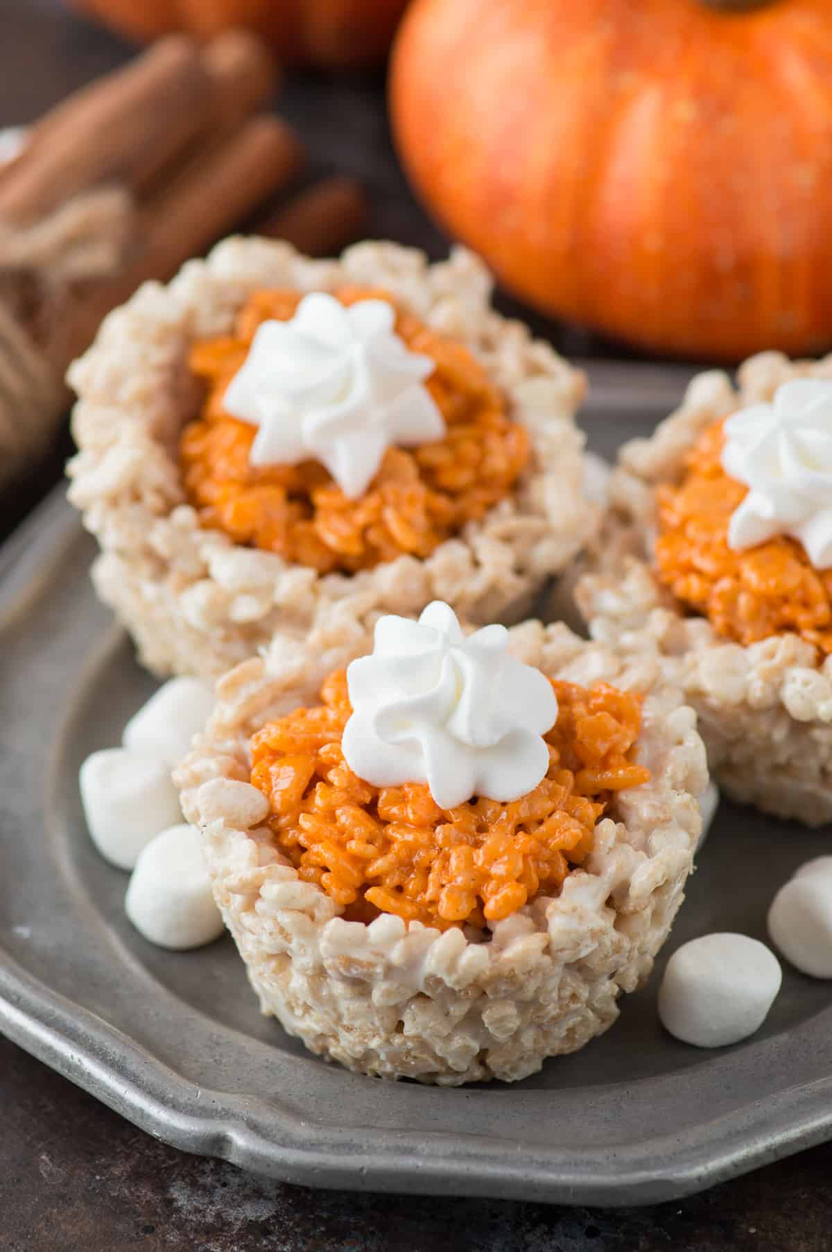 rice krispie treats that look like mini pumpkin pies on metal plate