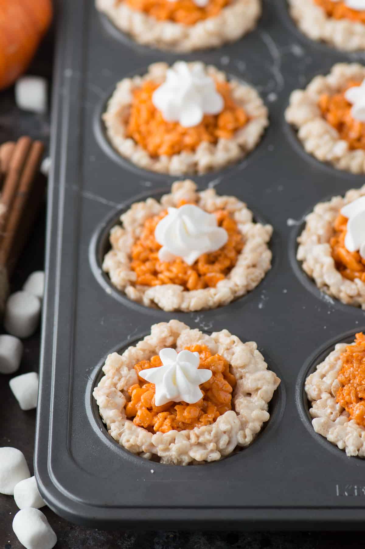 rice krispie treats that look like mini pumpkin pies in metal muffin pan