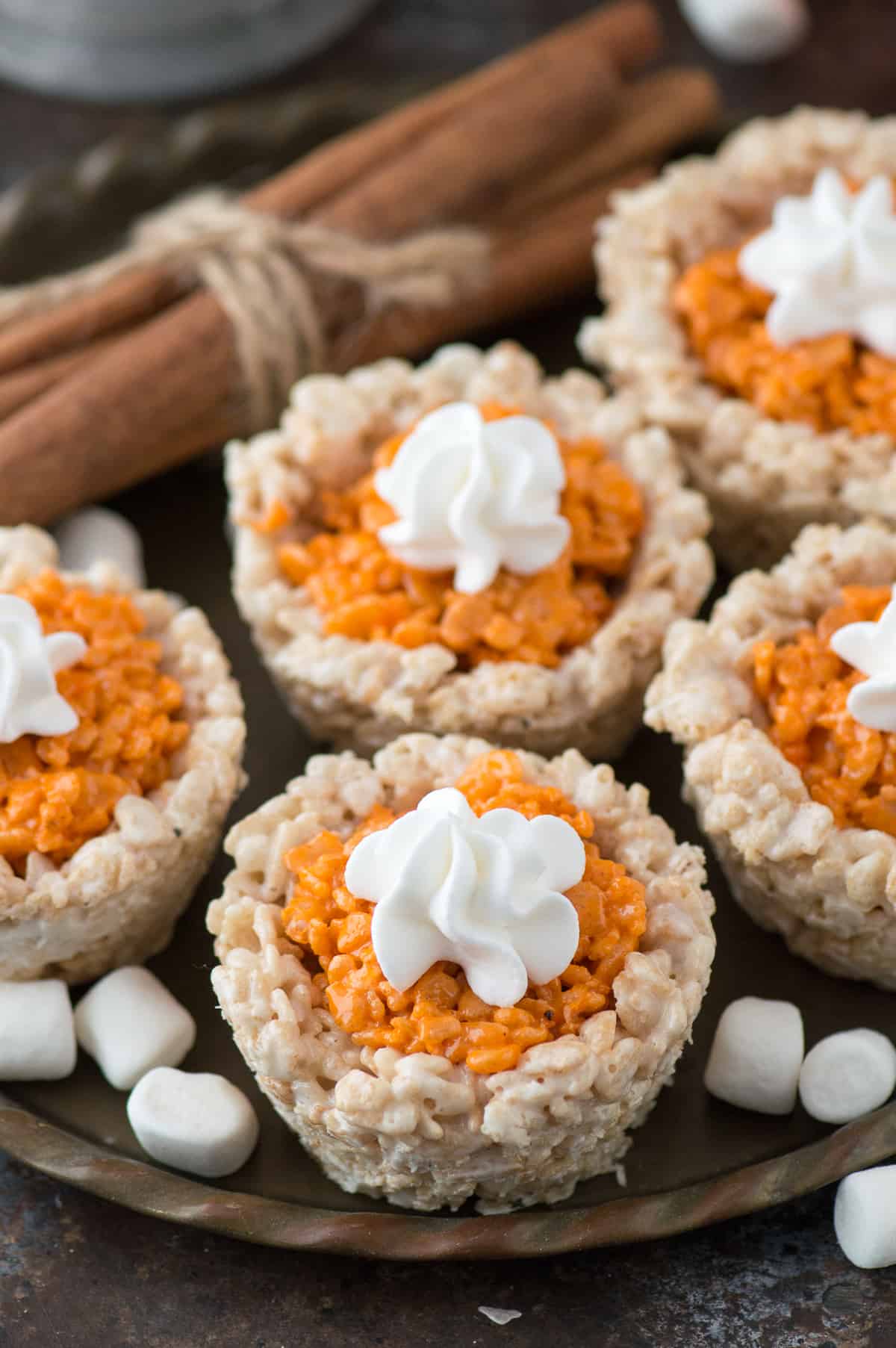 rice krispie treats that look like mini pumpkin pies on metal plate