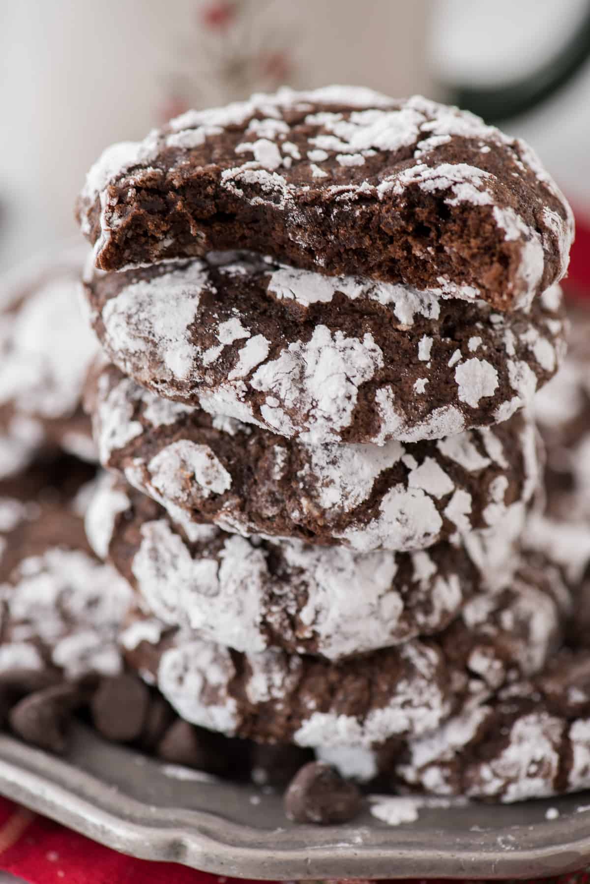 chocolate crinkle cookies rolled in powdered sugar stacked on a metal plate