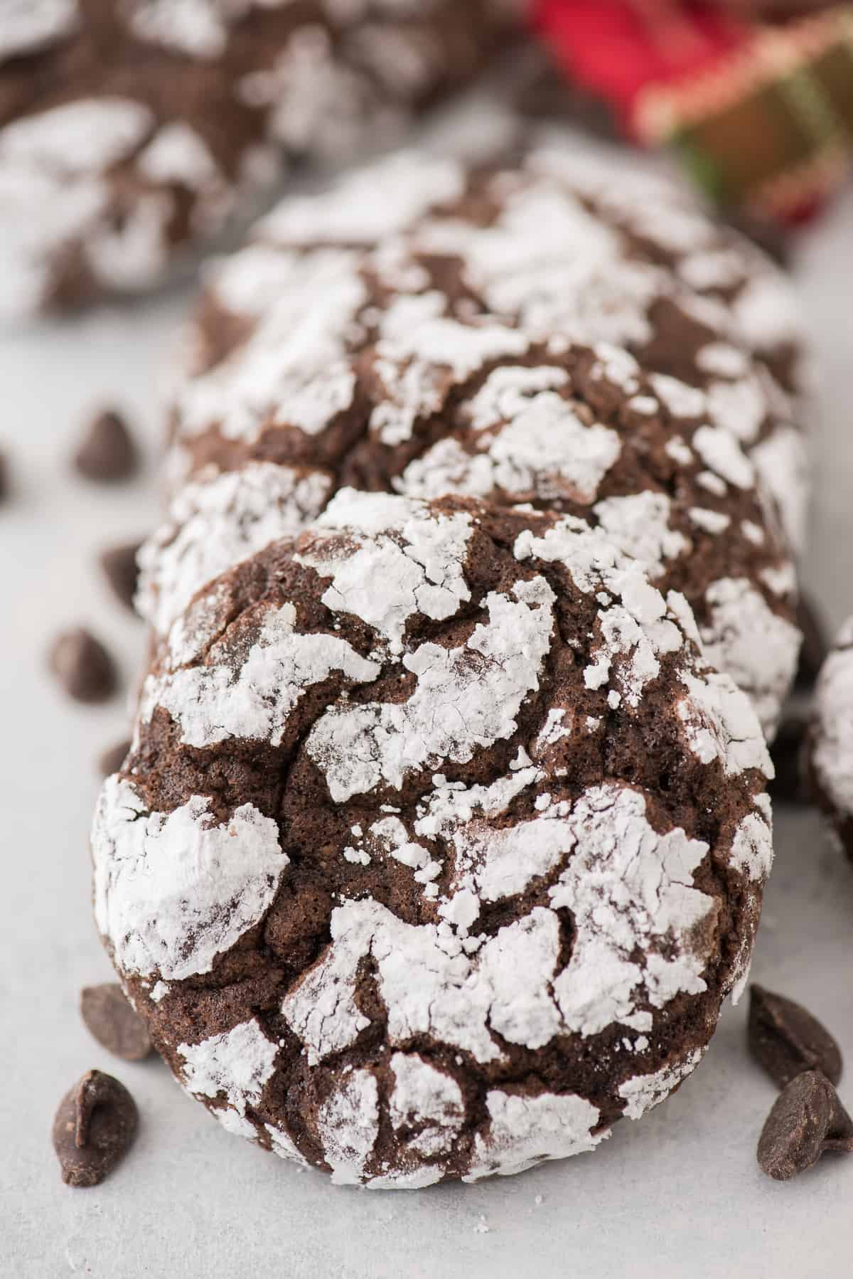 chocolate crinkle cookies rolled in powdered sugar displayed on gray surface