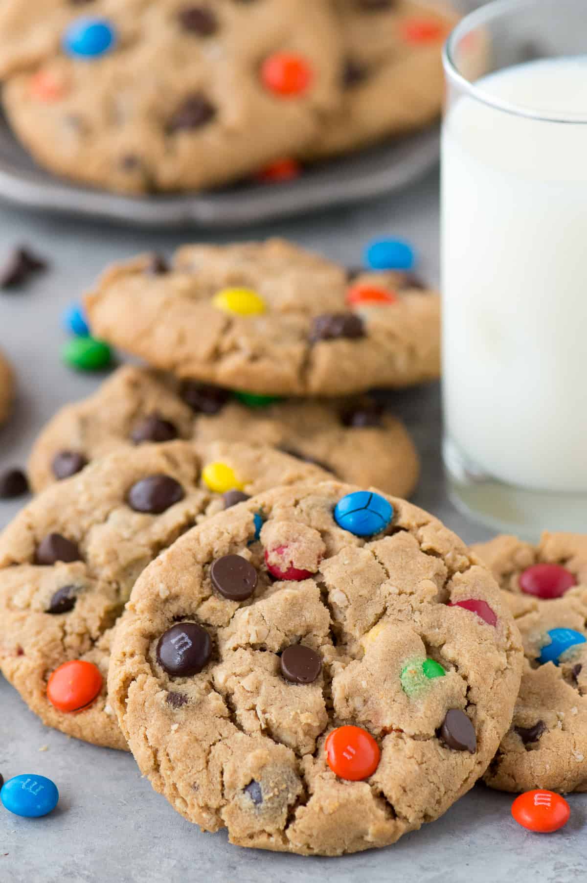 monster cookies with m&ms and chocolate chips with glass of milk in the background