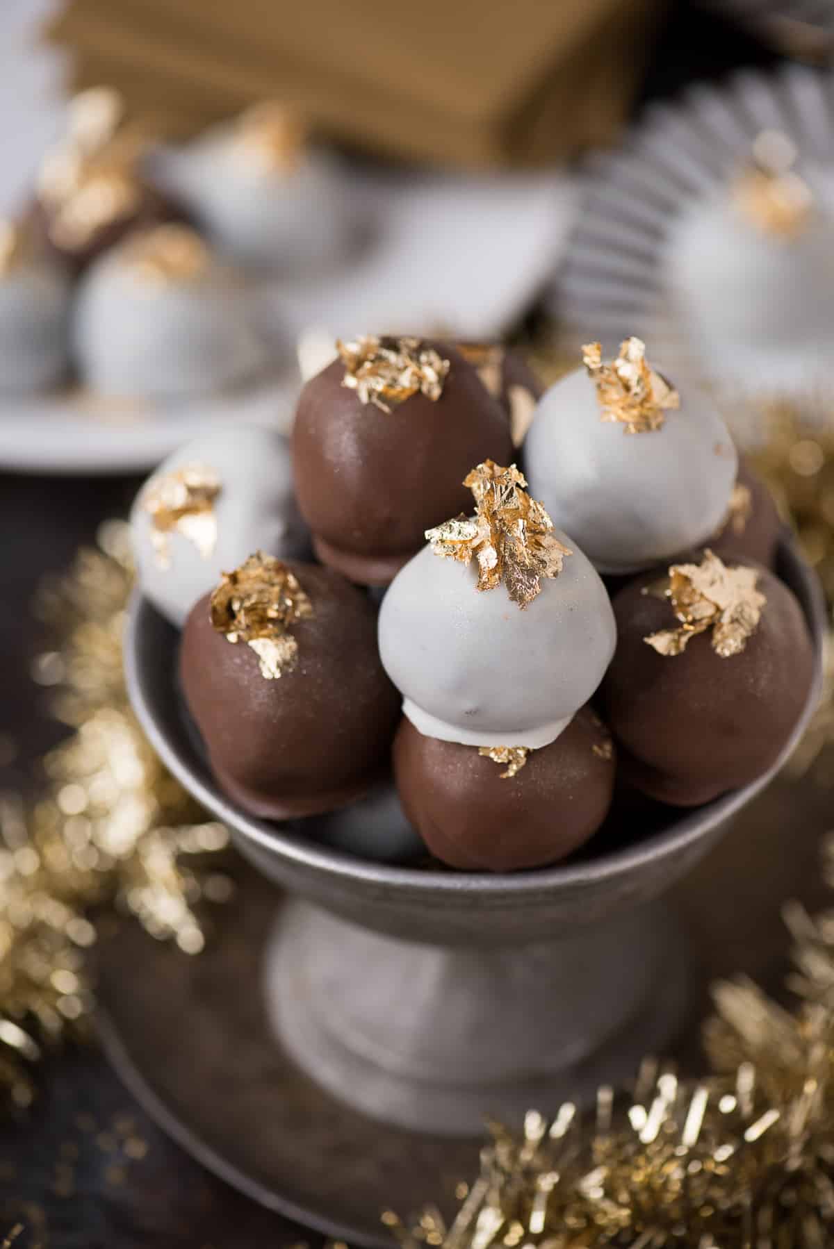 oreo balls displayed in metal bowl with edible gold flakes on top